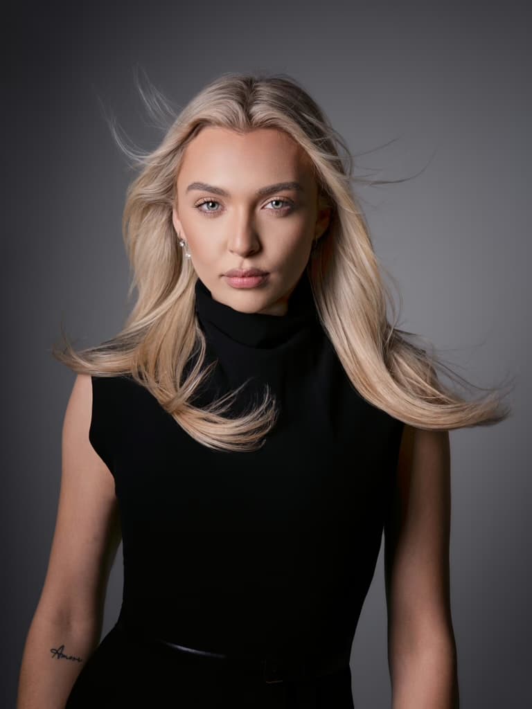Blondýnka v černém s vlajícími vlasy